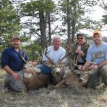 Four hunters and three whitetail bucks